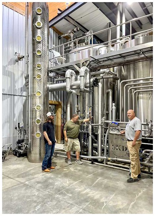 At Southern Kentucky Distillery, three man stand in front of the company's distillery equipment