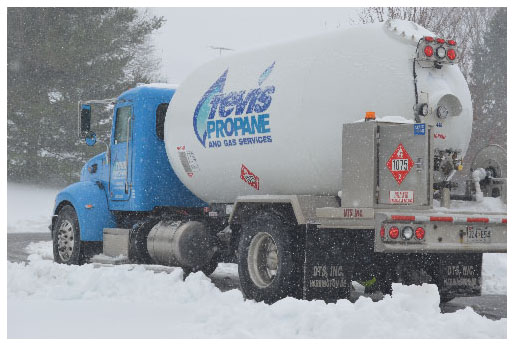 A Tevis Propane bobtail truck transports propane in a snowy landscape.