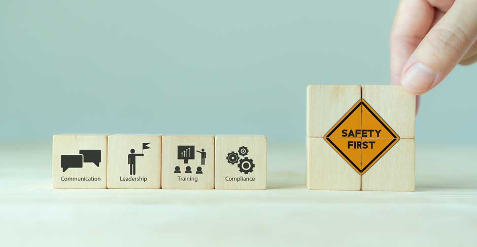 Wooden blocks showing workplace safety concepts: communication, leadership, training, compliance and safety first