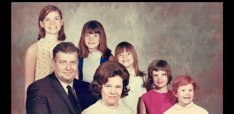 Old family photo of the Irish family — Bob and Marcia Irish sitting in front of their five daughters