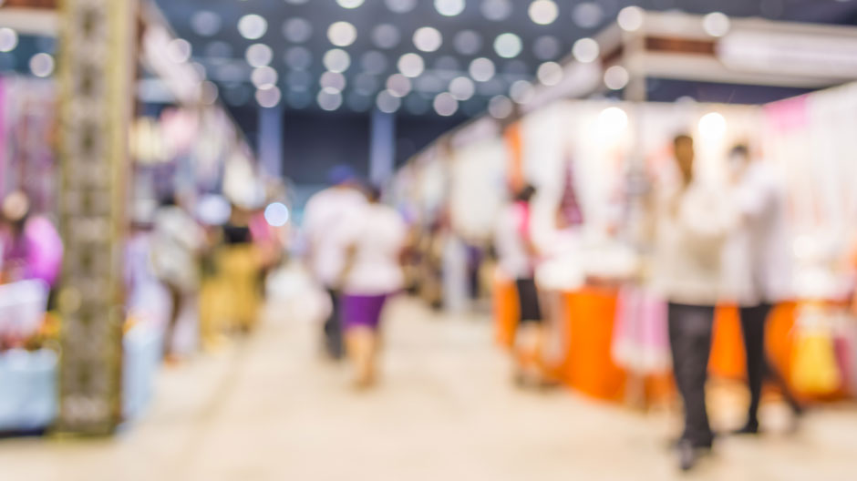 Blurred photo of people visiting booths at a trade show