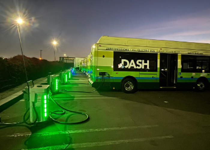 An electric bus being filled with propane