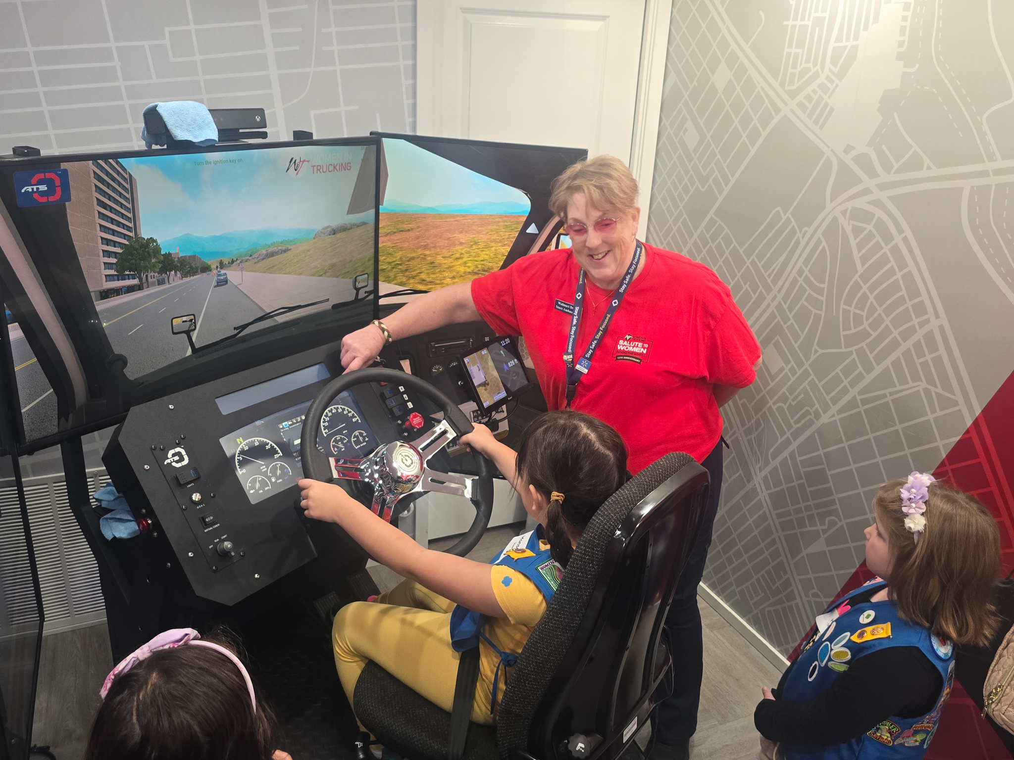 At the Truck Are for Girls: Fueling the Future event, a girl scout sits at the wheel of a driving simulator.