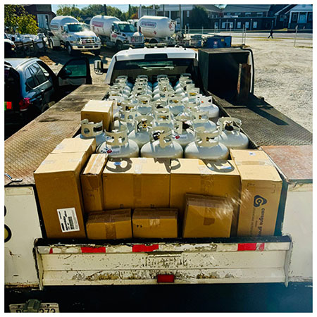 A truckbed is loaded with important supplies, including propane cylinders.