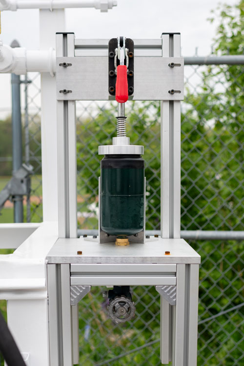 A 1-pound cylinder is connected to a cylinder evacuation system to empty the propane into a scavenger tank.