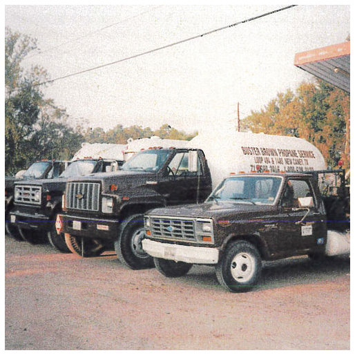 A service truck and three bobtails are parked next to each other; one bobtail reads "Buster Brown Propane Service"