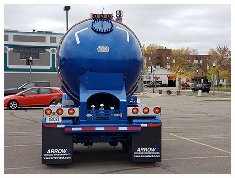 The back of a blue Arrow transport truck in a parking lot, printed with "#23."