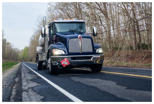 A fuel delivery truck drives down a roadway