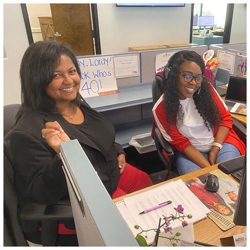 Two women train together at a desk in the ThompsonGas office