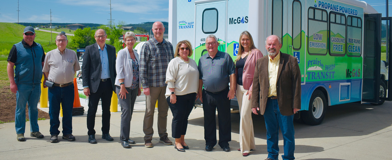 A photo of several people involved in the implementation of propane autogas in Prairie Hills fleets are pictured in front of a public bus.