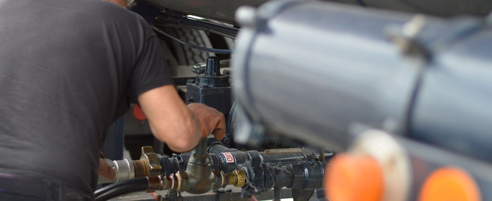 A man in protective gloves works on propane equipment