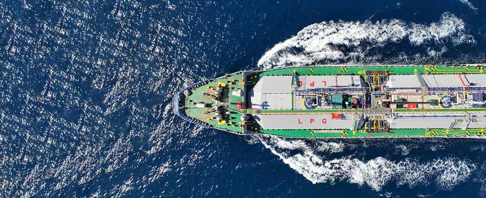 An aerial view of a green LPG transport ship traveling through the ocean