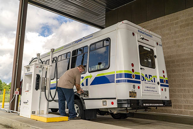 A man fills an autogas fleet bus at an autogas station.