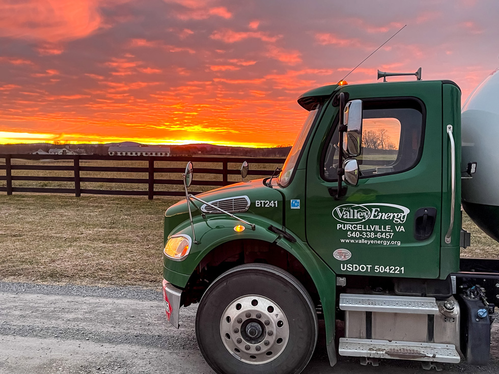 A picture of a propane delivery truck is featured against a stunning sunset.