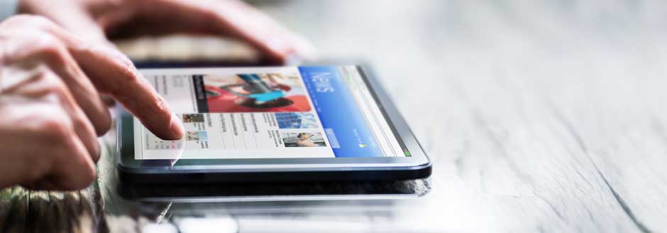 A person browses a news website on a tablet