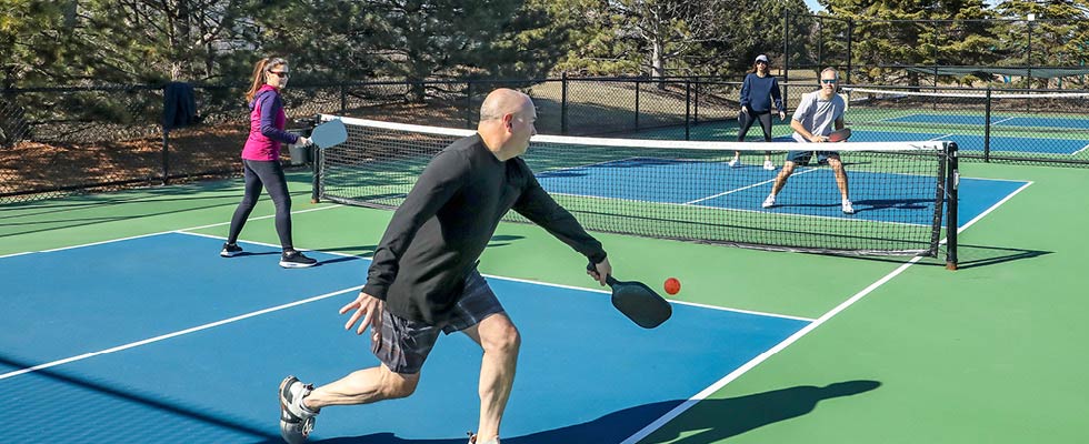 Two couples play tennis with each other, an example of how you might use free time.