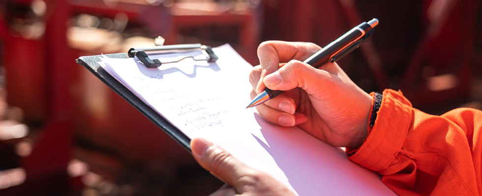 A person holds a clipboard and is assumed to be going through a list.