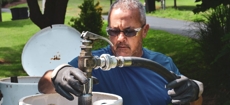 Man in sunglasses refills propane tank