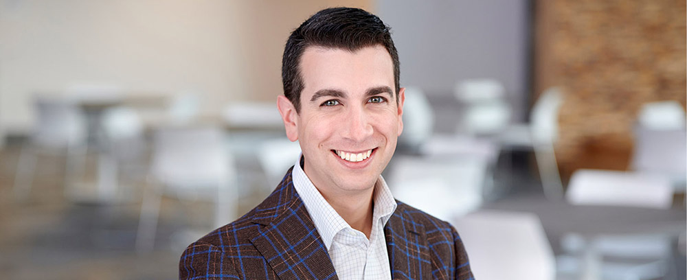 Martin Kirshner poses for a headshot picture in a brown suit.