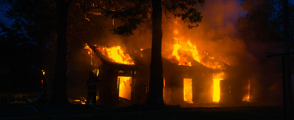 A fire is depicted erupting inside a house.