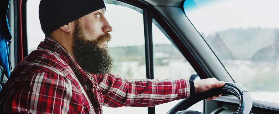 A truck driver drives a bobtail in cold weather