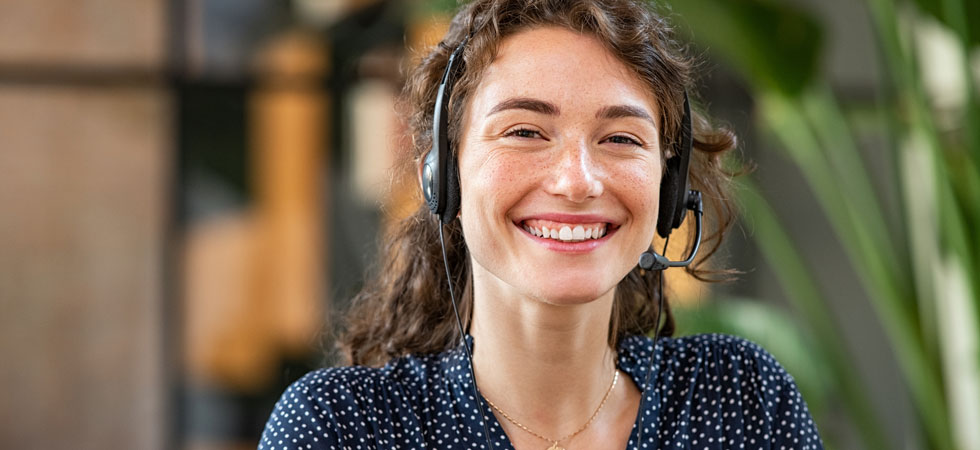 A woman answers a call through a microphone headset
