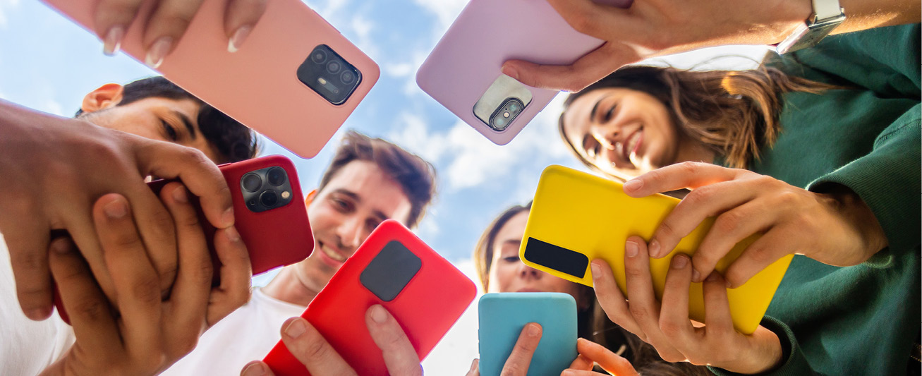 A group of people in a circle with their phone extended out