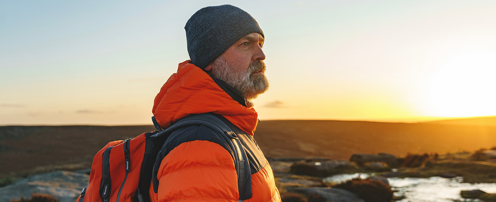 A man looking into the distance with the sun in the background