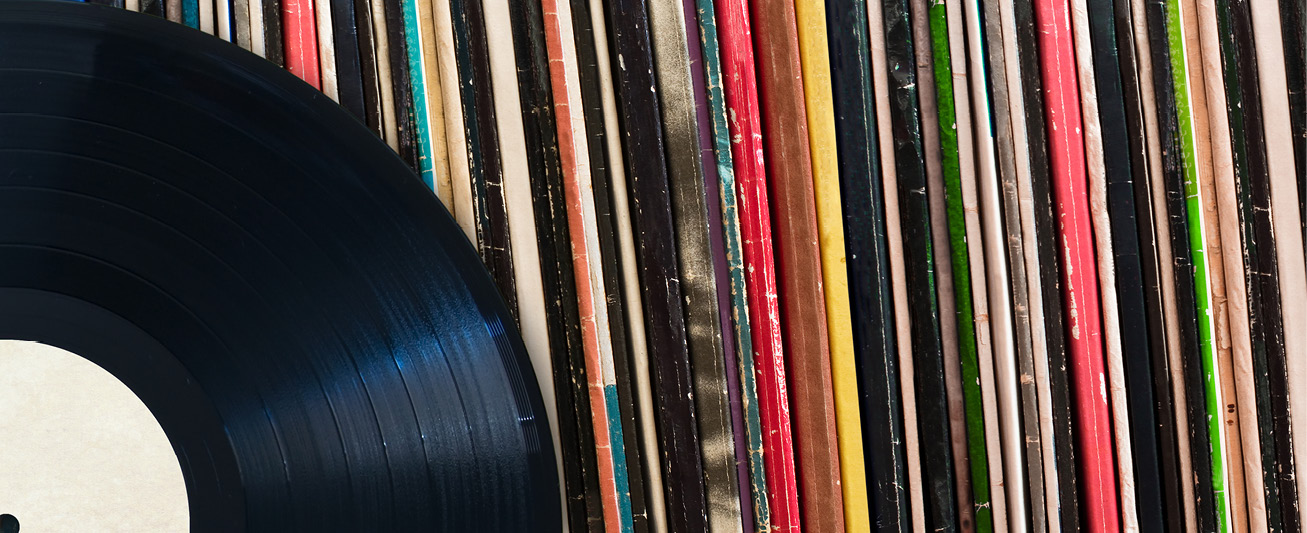 A record is pictured against a backdrop of record covers.