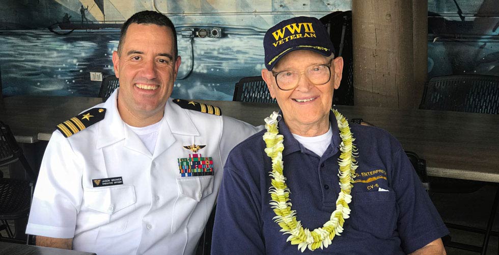 Jason Grower smiles for the camera alongside a World War II veteran