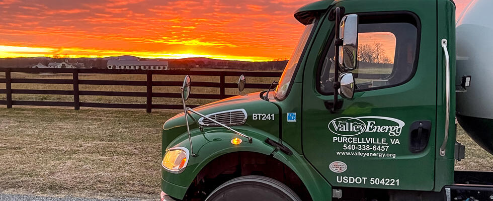 A picture of a propane delivery truck is featured against a stunning sunset.