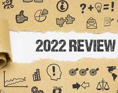 Brown paper is torn back to reveal "2022 Review" on the paper underneath
