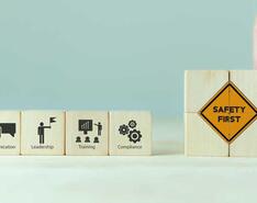Wooden blocks showing workplace safety concepts: communication, leadership, training, compliance and safety first