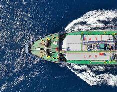An aerial view of a green LPG transport ship traveling through the ocean