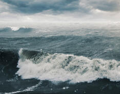 A sea is depicted amid rough, extremely choppy waters.