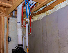 A stock photo showing pipes going into a ceiling/floor