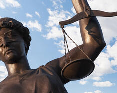 A picture depicts a statue of "lady justice" blindfolded and holding the measuring scales.