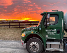 A picture of a propane delivery truck is featured against a stunning sunset.