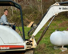 Reagan Bonnette of Stringer Oil & LP Gas operates a Bobcat excavator in assistance to western North Carolina residents.