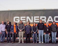 The Generac team stands in front of a trailer with the Generac logo