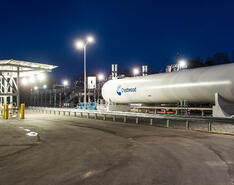 White Crestwood propane storage tanks sit on the company lot against a night-sky background.