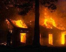 A fire is depicted erupting inside a house.