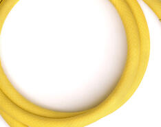 A yellow, flexible corrugated stainless-steel tube is pictured against a white backdrop.