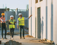 A picture shows construction professionals walking along a job site.