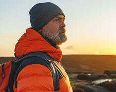 A man looking into the distance with the sun in the background