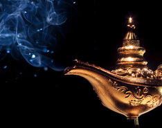 A golden genie lamp emits smoke and sparkles