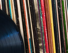 A record is pictured against a backdrop of record covers.