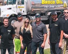 Robert and Angela Brown stand with other members of the Broco Oil team in front of a silver Broco Oil propane truck.
