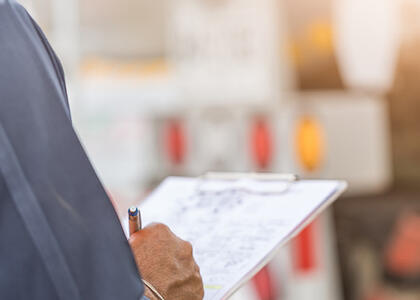 A person writing on a clipboard