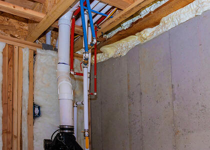 A stock photo showing pipes going into a ceiling/floor